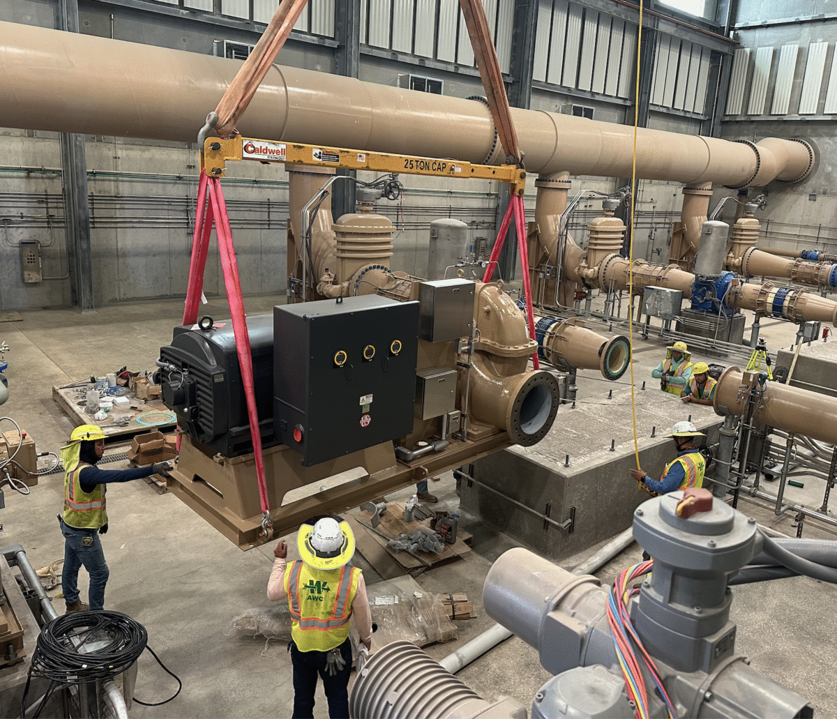Workers maneuver a pump into place at the lake's pump station.